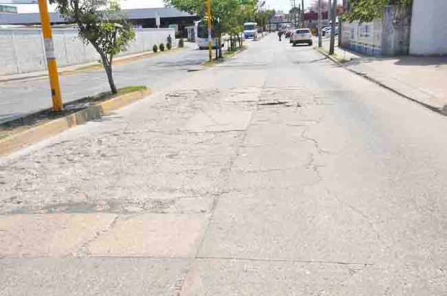 Se quejan transportistas de calle llena de hoyos